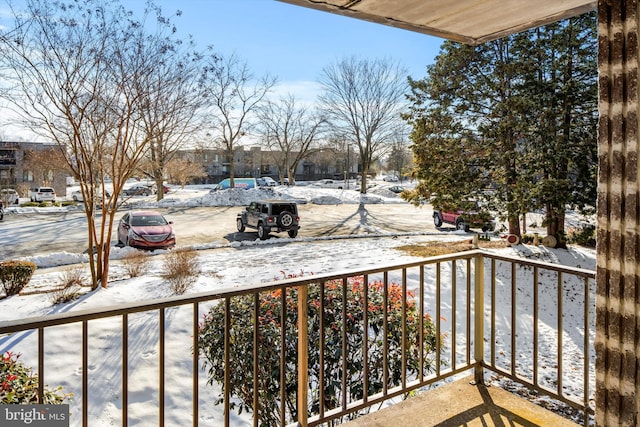 view of snow covered back of property