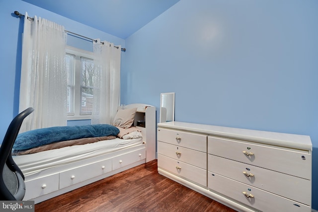 bedroom featuring lofted ceiling and dark hardwood / wood-style floors