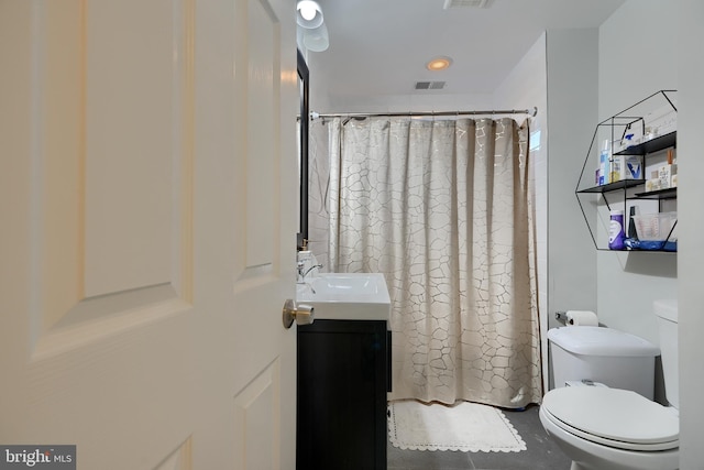 bathroom featuring vanity, toilet, and walk in shower