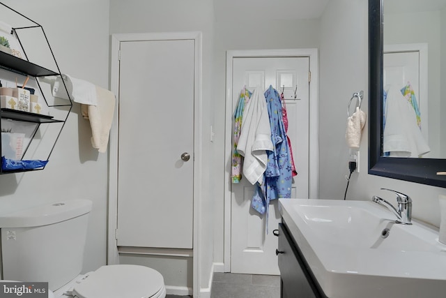 bathroom with tile patterned flooring, vanity, and toilet