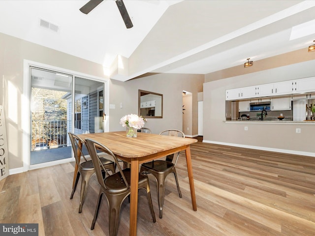 dining area with lofted ceiling, ceiling fan, and light wood-type flooring