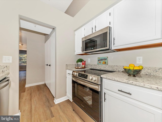 kitchen with light stone counters, stainless steel appliances, light hardwood / wood-style flooring, and white cabinets