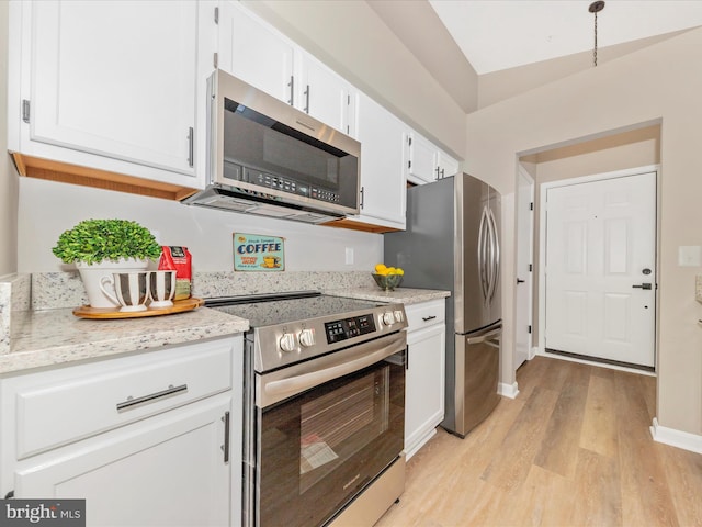 kitchen with stainless steel appliances, light stone countertops, light hardwood / wood-style flooring, and white cabinets