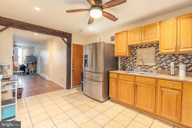 kitchen featuring sink, ceiling fan, stainless steel refrigerator with ice dispenser, tasteful backsplash, and a baseboard radiator