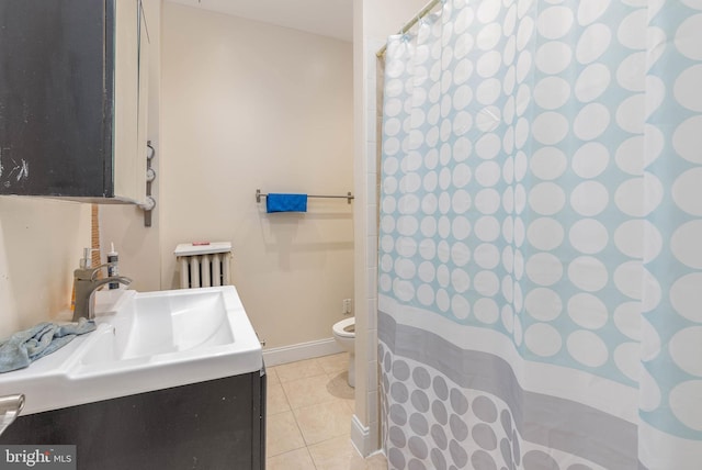 bathroom with tile patterned flooring, vanity, radiator, and toilet