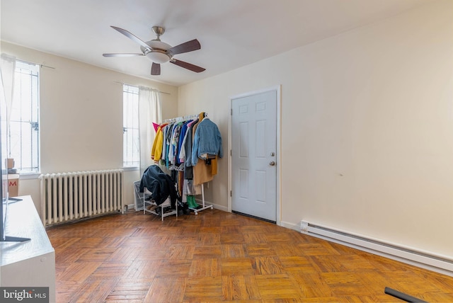 spare room featuring a baseboard heating unit, dark parquet flooring, radiator heating unit, and ceiling fan