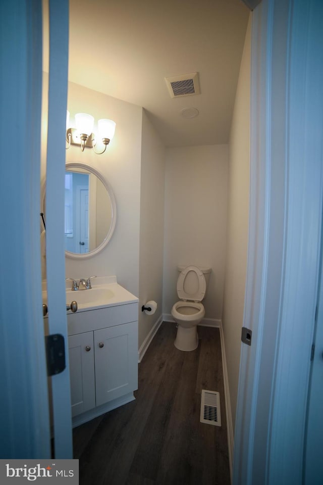 bathroom with vanity, hardwood / wood-style floors, and toilet