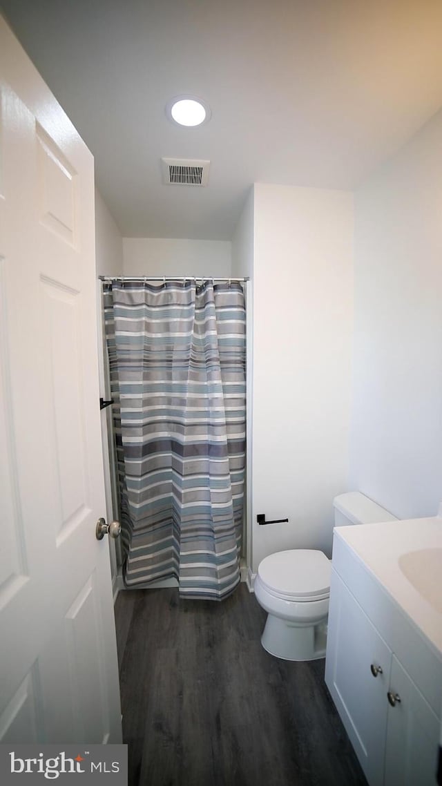 bathroom with hardwood / wood-style flooring, vanity, toilet, and a shower with shower curtain