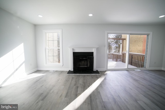 unfurnished living room with hardwood / wood-style flooring and a wealth of natural light