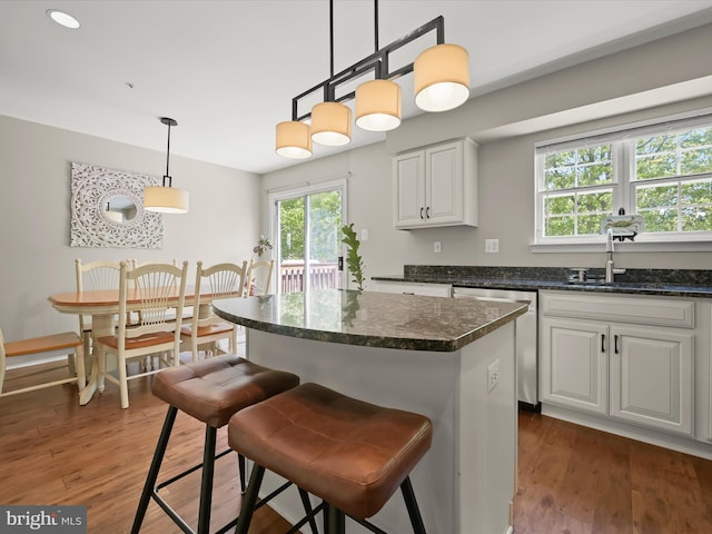 6422 Frothingham Ct, Elkridge, MD 21075 - kitchen featuring stainless steel dishwasher, a sink, wood finished floors, a center island, and white cabinetry
