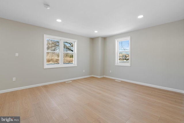 unfurnished room featuring plenty of natural light and light hardwood / wood-style flooring