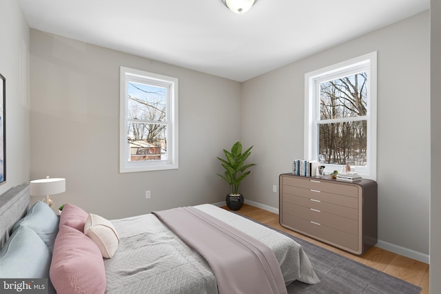 bedroom with multiple windows and light wood-type flooring