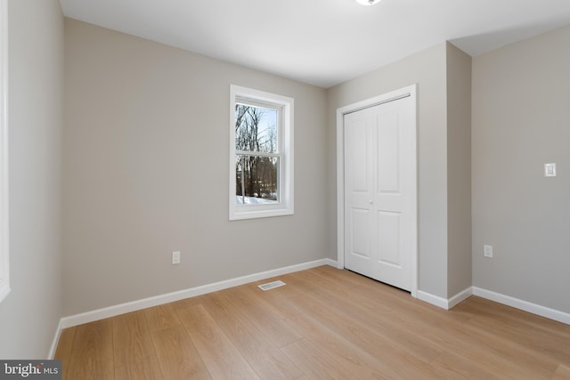 unfurnished bedroom featuring a closet and light hardwood / wood-style flooring