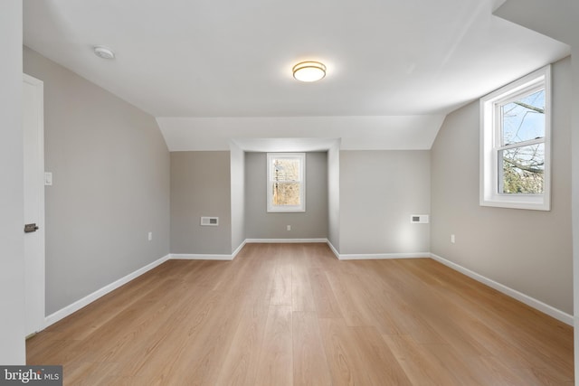 bonus room featuring vaulted ceiling and light wood-type flooring