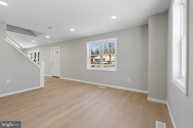 empty room with plenty of natural light and light hardwood / wood-style floors