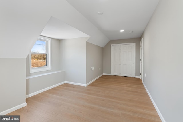 bonus room featuring lofted ceiling and light hardwood / wood-style floors