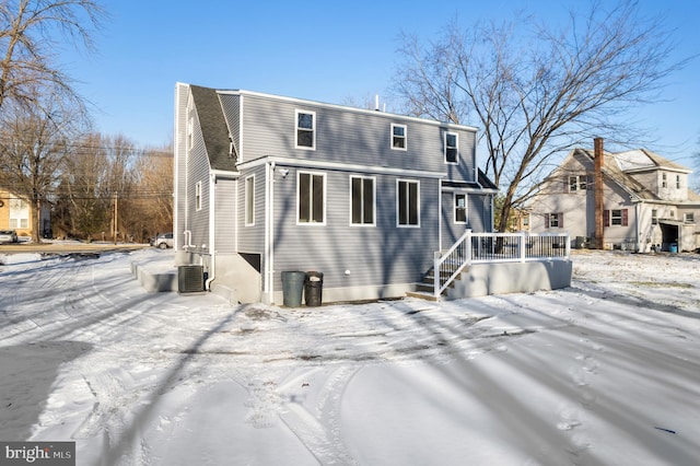 snow covered rear of property with central air condition unit