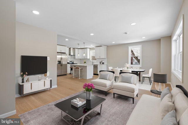 living room with sink and light wood-type flooring