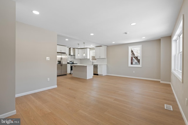 unfurnished living room featuring sink and light hardwood / wood-style flooring