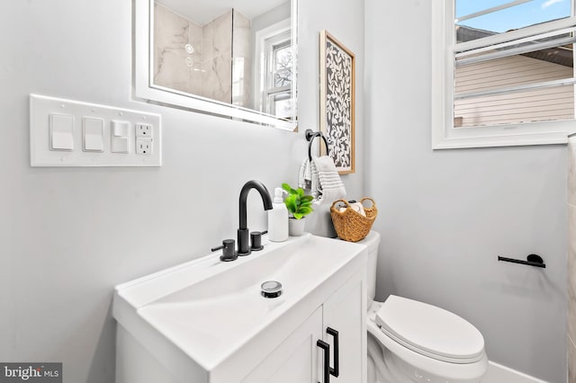 bathroom with vanity, a wealth of natural light, and toilet