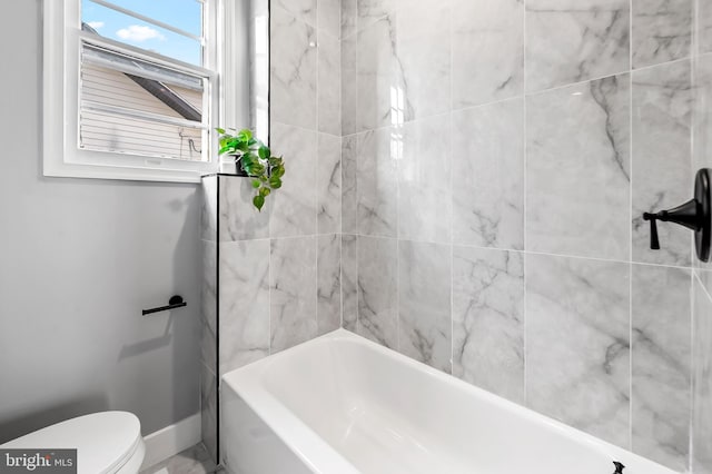 bathroom with tiled shower / bath and toilet