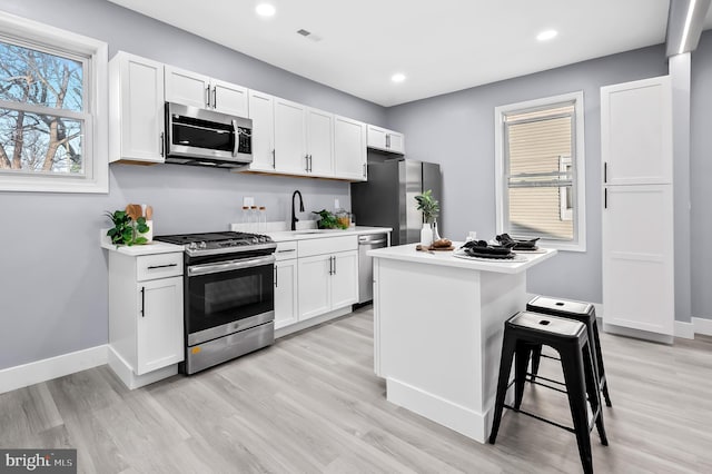 kitchen with white cabinetry, a kitchen island, and appliances with stainless steel finishes