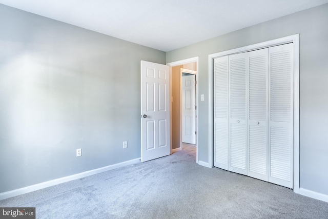 unfurnished bedroom featuring baseboards, a closet, and carpet