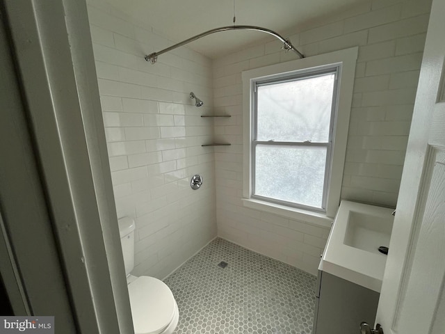 bathroom with vanity, tiled shower, a wealth of natural light, and toilet