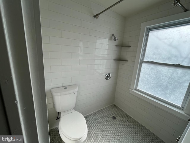 bathroom with tiled shower and toilet