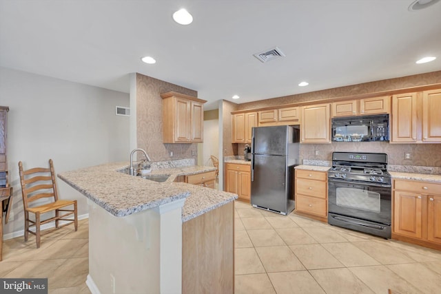 kitchen with black appliances, sink, a kitchen bar, kitchen peninsula, and light stone countertops