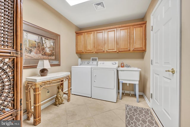 laundry room featuring light tile patterned flooring, cabinets, and washer and clothes dryer