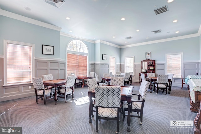 dining area featuring crown molding and carpet