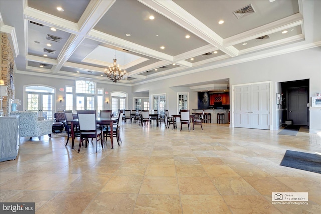 dining room with a high ceiling, ornamental molding, coffered ceiling, and french doors