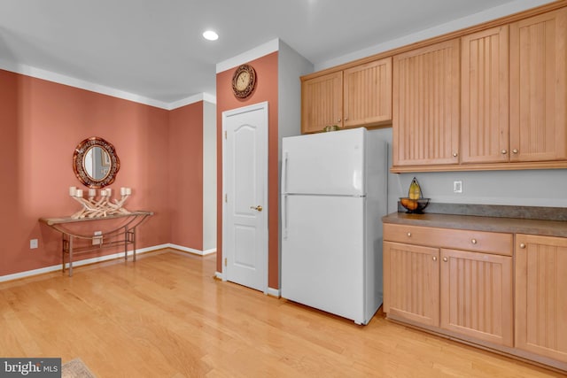 kitchen featuring light brown cabinets, white fridge, and light wood-type flooring