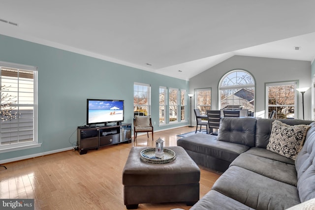 living room with vaulted ceiling, plenty of natural light, and light hardwood / wood-style floors