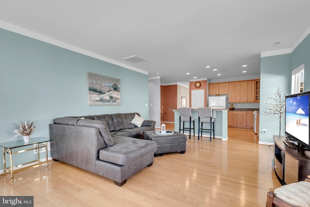 living room with light hardwood / wood-style flooring and ornamental molding