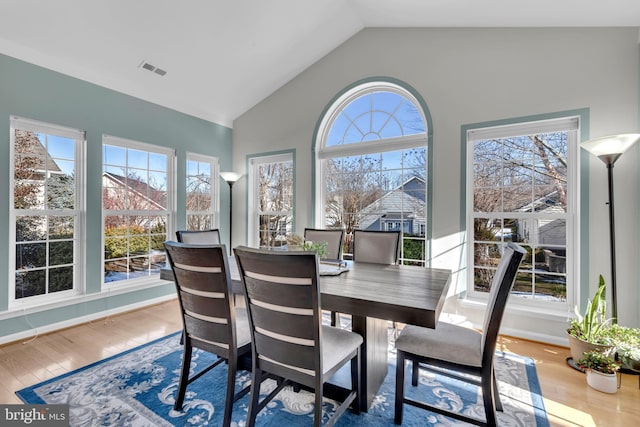 dining area featuring vaulted ceiling and hardwood / wood-style floors