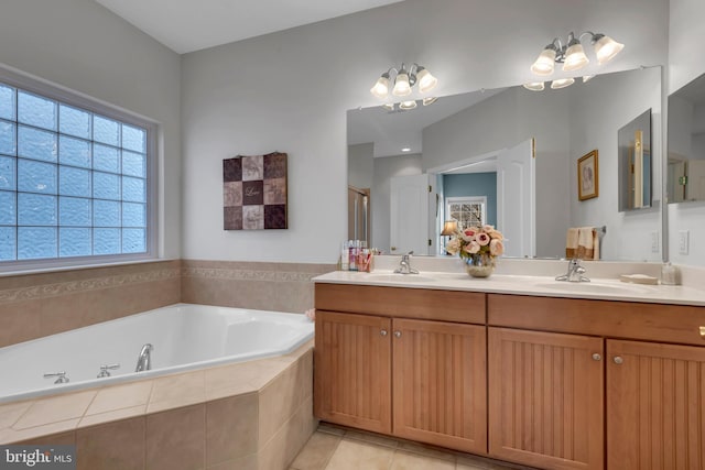 bathroom with tile patterned floors, tiled bath, and vanity