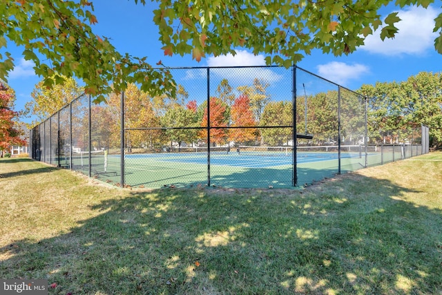 view of tennis court with a yard