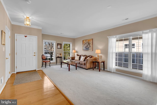 foyer featuring ornamental molding, plenty of natural light, and light hardwood / wood-style flooring