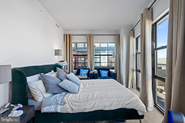 bedroom with multiple windows and light wood-type flooring