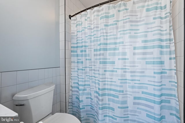 bathroom featuring tile walls and a shower with shower curtain