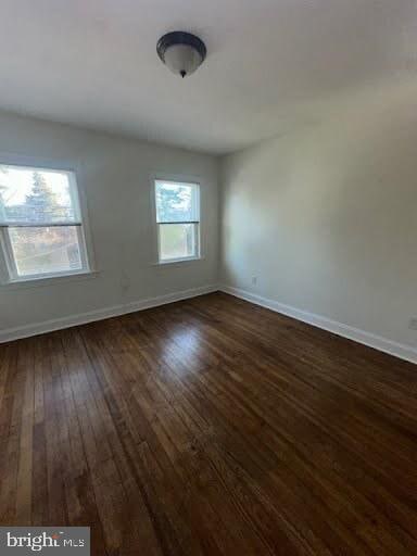 empty room with dark wood-type flooring