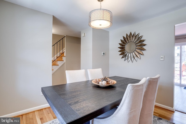 dining space with baseboards, stairs, and wood finished floors