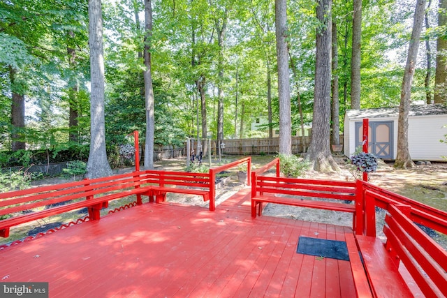 wooden terrace with a fenced backyard, an outbuilding, and a storage shed