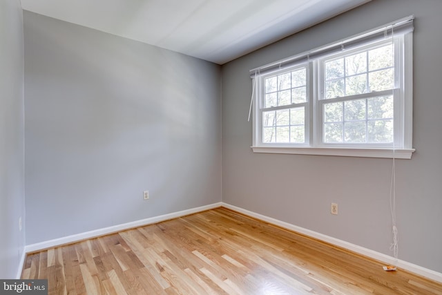 empty room with baseboards and wood finished floors