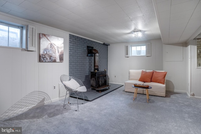 living room featuring crown molding, a wood stove, and carpet