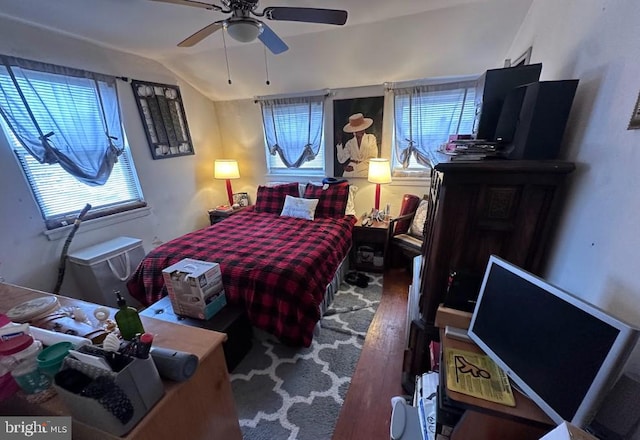 bedroom with ceiling fan, lofted ceiling, and wood-type flooring