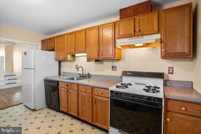 kitchen with white refrigerator, black dishwasher, sink, and gas range oven