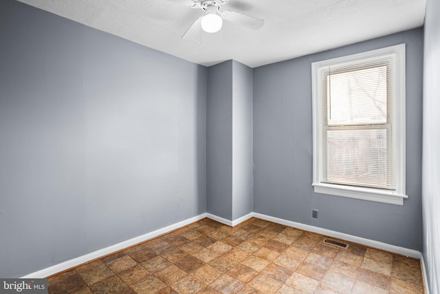 empty room with a textured ceiling and ceiling fan